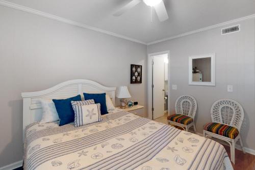 a bedroom with a large bed and two chairs at Southwinds II in Atlantic Beach