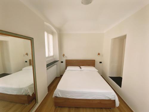 a bedroom with two beds and a mirror at Appartamento Villa Cristina in Genova