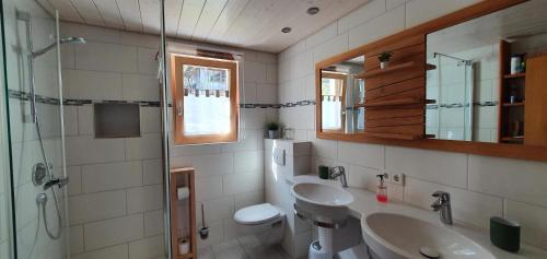 łazienka z 2 umywalkami i prysznicem w obiekcie Alpenliebe Montafon w mieście Silbertal