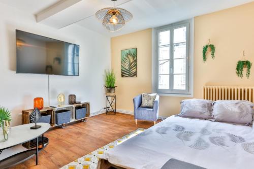 un salon avec un lit et une télévision dans l'établissement LA FABRIQUE #Hyper Centre #Baby foot #Terrasse, à Cognac