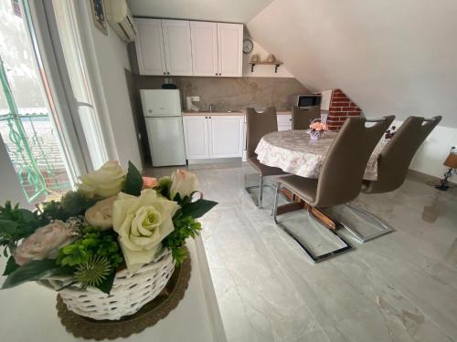 Mate Apartments في قشتيلا: مطبخ مع طاولة وكراسي و إناء من الزهور