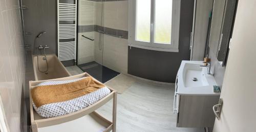 a bathroom with a sink and a chair next to a toilet at Villa avec piscine dans Vallon Pont d’Arc in Vallon-Pont-dʼArc