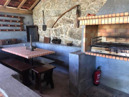 a bar with a table and a grill in a room at CASA DAS 4 MARIAS in Pinheiro de Ázere