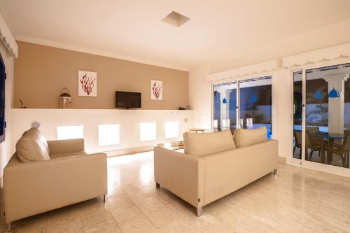 ein Wohnzimmer mit 2 Sofas und einem TV in der Unterkunft Villa Bahía in Corralejo