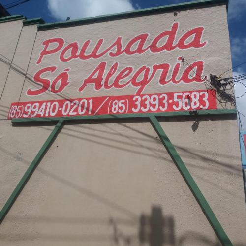 una señal para un restaurante al lado de un edificio en Pousada Só Alegria, en Fortaleza