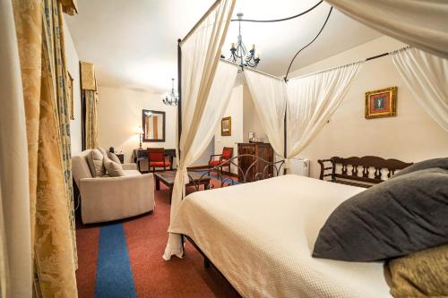 a bedroom with a canopy bed and a living room at Alvar Fañez in Úbeda