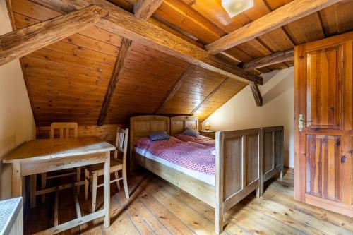 a bedroom with a bed in a room with wooden ceilings at Penzion a hostinec Kyjovská terasa in Krásná Lípa