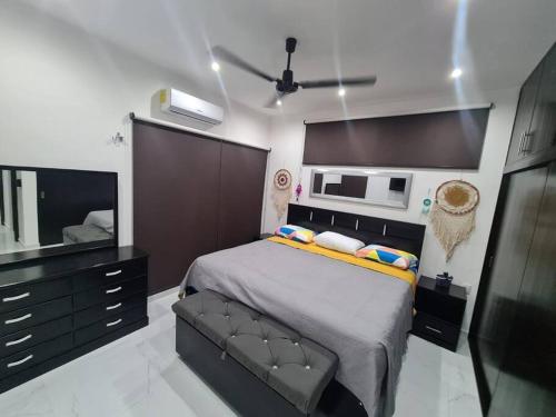 a bedroom with a large bed and a microwave at CASA PALOMA 2 EN SEGUNDA PLANTA CERCA DE AEROPUERTO Y CENTRO COMERCIAL in Chetumal