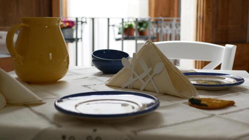 una mesa con platos azules y blancos y un jarrón en Palazzo Donna Chicchi, en Galatone