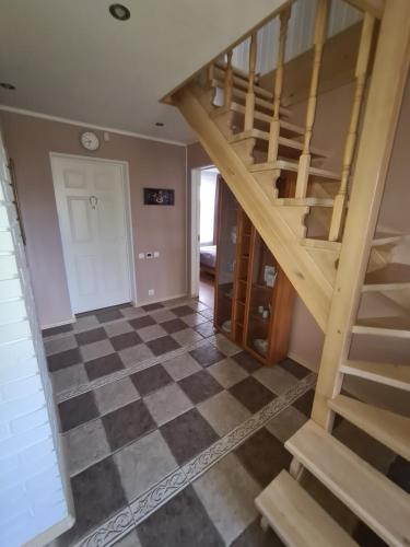 a staircase in a room with a checkered floor at Rähni Guesthouse Lake Peipsi in Vilusi