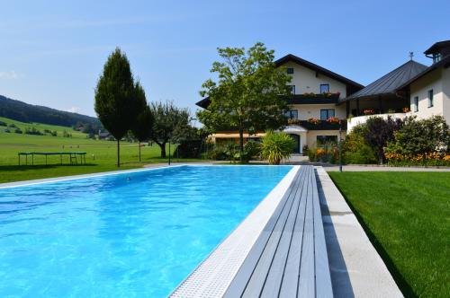a swimming pool in front of a house at Pension Anna in Mondsee