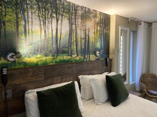 a bedroom with a painting of a forest at contemporary quiet countryside retreat in Horsley