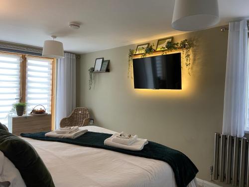 um quarto com duas camas e uma televisão na parede em contemporary quiet countryside retreat em Horsley