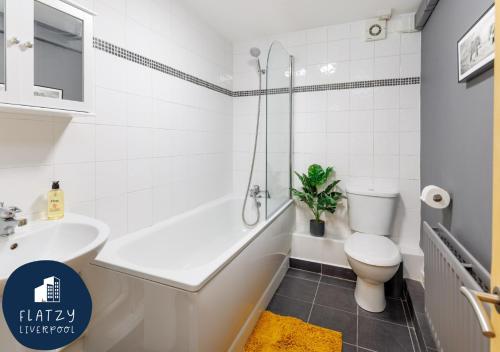baño blanco con bañera, aseo y lavamanos en FLATZY - Modern Apartment Close to Football Stadiums en Liverpool