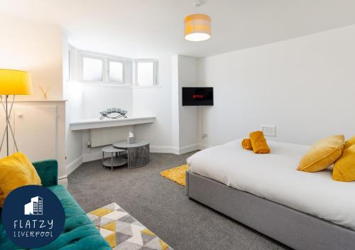 a bedroom with a bed and a couch and a table at FLATZY - Modern Apartment Close to Football Stadiums in Liverpool