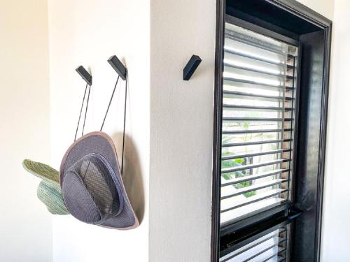 a hat hanging on a wall next to a window at Zen Oceanfront Condo in Kralendijk