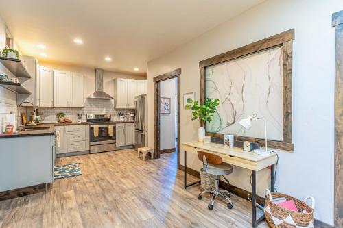 an open kitchen with a desk and a table in it at The Electric Bungalow in Bigfork