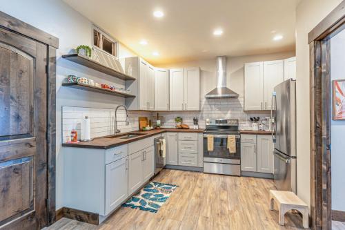 a kitchen with white cabinets and stainless steel appliances at The Electric Bungalow in Bigfork
