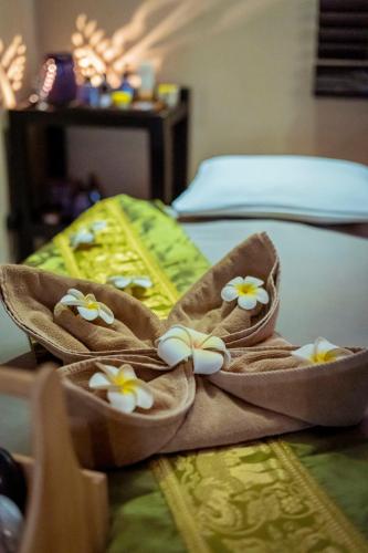 a pair of sandals with flowers on a bed at Ibis Styles Accra Airport in Accra