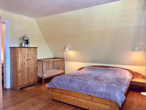 1 dormitorio con cama de madera y cuna en Chalupa Sunny Cottage en Svoboda nad Úpou