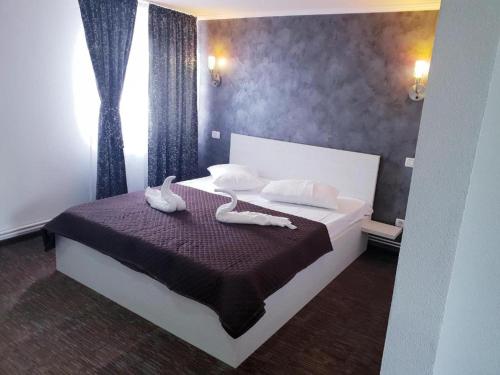 a bedroom with a bed with two towels on it at La Zinculescu in Albeştii Pămînteni
