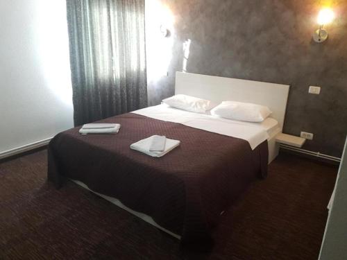 a hotel room with a bed with two towels on it at La Zinculescu in Albeştii Pămînteni