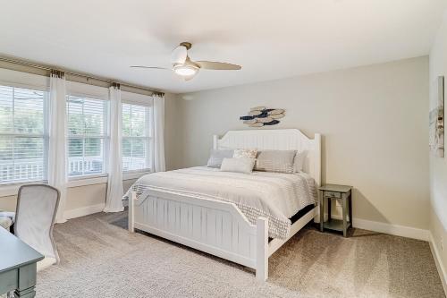 a white bedroom with a white bed and windows at Hammock Breeze 21 in Hilton Head Island