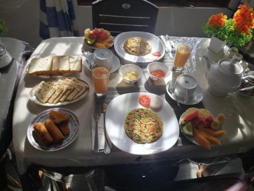 a table with plates of food on top of it at Lavendra Guset House in Adams Peak