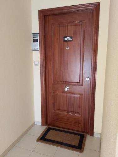 a wooden door with a sign on it at Saudade Hostal Cafetería in A Coruña