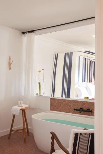 a bath tub in a bathroom with a window at Brindos, Lac & Château - Relais & Châteaux - Anglet Biarritz in Anglet
