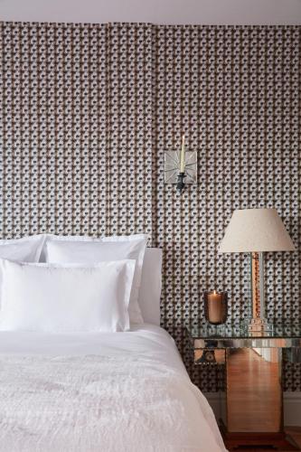 a bedroom with a bed and a clock on a wall at Brindos, Lac & Château - Relais & Châteaux - Anglet Biarritz in Anglet