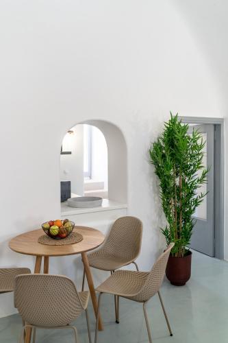 a dining room with a table and chairs and a plant at Evanthia Best View Thirassia Island Hotel in Thirasia