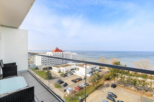 a balcony with a view of a parking lot and the ocean at Balticus Apartamenty Deluxe Promenada Gwiazd 14 in Międzyzdroje