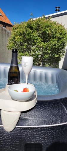 a table with a bowl and a drink and a wine bottle at Sea-renity 23 met sauna en jacuzzi in Eggewaartskapelle