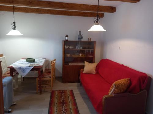 een woonkamer met een rode bank en een tafel bij GALAMBLAK Vendégház in Abaújszántó