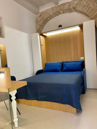 a bedroom with a blue bed and a wooden door at L'Alfiere in Corato