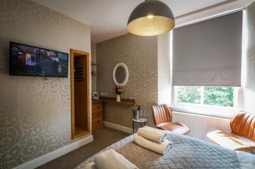 a bedroom with a bed and a tv on the wall at Glen Wynne Windermere - FREE off-site Health Club access with Pool, Sauna, Steam Room & Gym Short 5 Minute Drive Away in Windermere