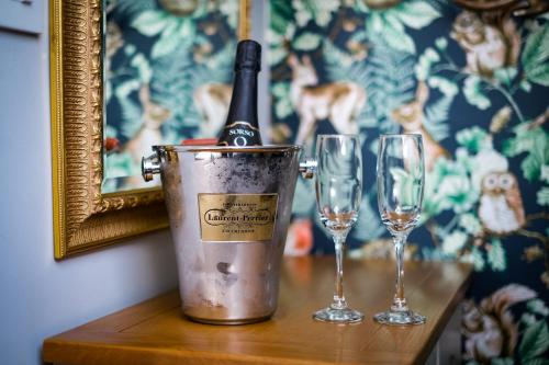 a bottle of wine in a bucket next to two wine glasses at Glen Wynne Windermere - FREE off-site Health Club access with Pool, Sauna, Steam Room & Gym Short 5 Minute Drive Away in Windermere