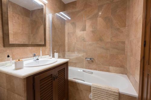 a bathroom with a sink and a bath tub at Blue Charme in La Herradura