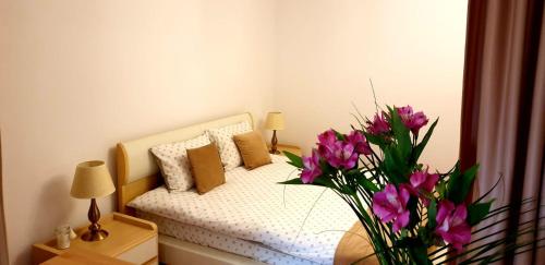 een slaapkamer met een bed met een vaas met bloemen bij Brasov Studio in Braşov