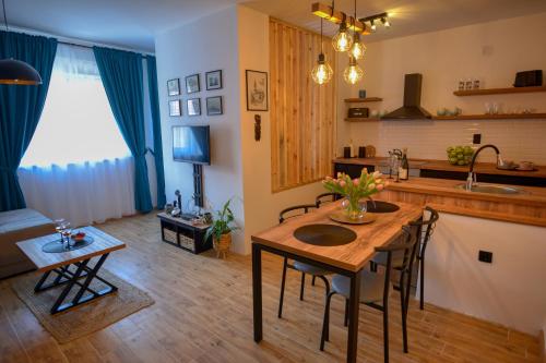 Dream Apartment Vršac في فرساك: مطبخ وغرفة معيشة مع طاولة وكراسي