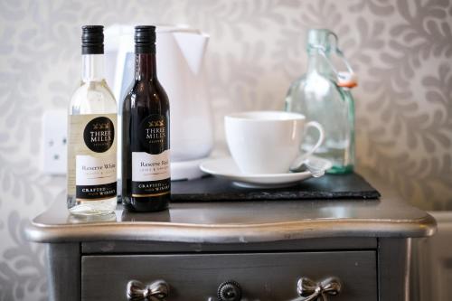 two bottles of wine sitting on top of a table at Glen Wynne Windermere - FREE off-site Health Club access with Pool, Sauna, Steam Room & Gym Short 5 Minute Drive Away in Windermere