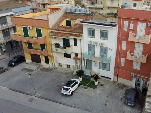 a white car parked in a parking lot in front of buildings at B&B Angelo e Silvana in Licata