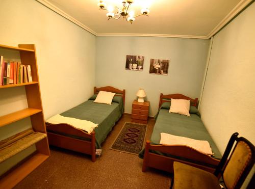 Zimmer mit 2 Betten und Bücherregal in der Unterkunft Posada-18 in Malón