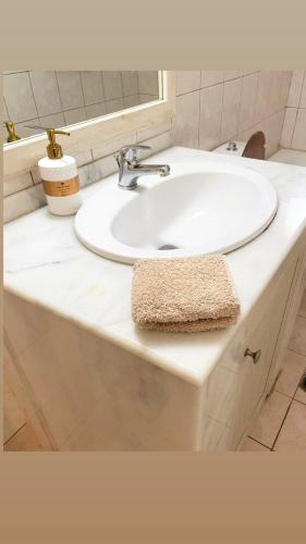 een badkamer met een witte wastafel en een spiegel bij Casa Dino Bello in Rhodos-stad