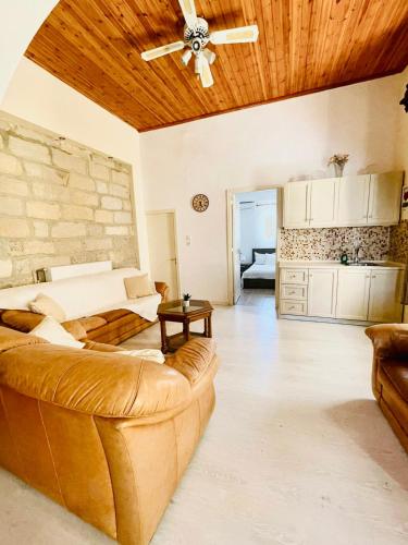 een woonkamer met een bank en een plafondventilator bij Casa Dino Bello in Rhodos-stad