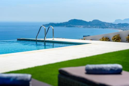a swimming pool with a view of the water at Diamond Hill Villa in Koskinou