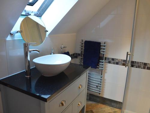 uma casa de banho com um lavatório e um espelho num balcão em Dragon Hill Barn em Matlock