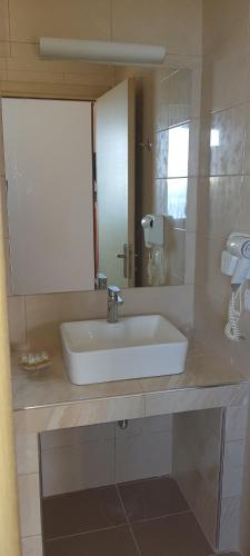 a bathroom with a white sink and a mirror at Villa Molivos Castle in Mithymna