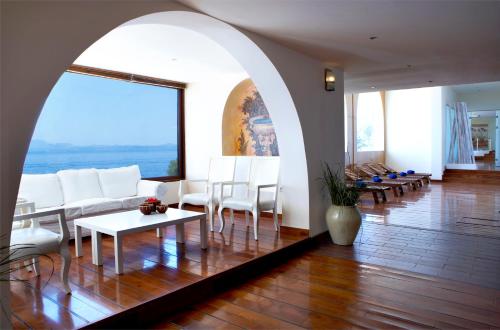 a living room with white furniture and a large window at Sunshine Corfu Hotel And Spa in Nisakion